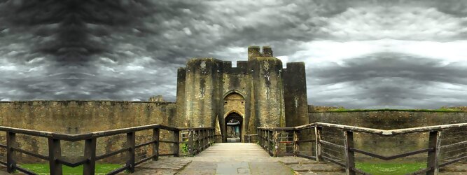 Trip Angebote Reisetipps - Caerphilly Castle - ein Bollwerk aus dem 13. Jahrhundert in Wales, Vereinigtes Königreich. Mit einem aufsehenerregenden Turm, der schiefer ist wie der Schiefe Turm zu Pisa. Wie jede Burg mit Prestige, hat sie auch einen Geist, „The Green Lady“ spukt in den Gemächern, wo ihr Geliebter den Tod fand. Wo man in Wales oft – und nicht ohne Grund – das Gefühl hat, dass ein Schloss ziemlich gleich ist, ist Caerphilly Castle bei Cardiff eine sehr willkommene Abwechslung. Die Burg ist nicht nur deutlich größer, sondern auch älter als die Burgen, die später von Edward I. als Ring um Snowdonia gebaut wurden.